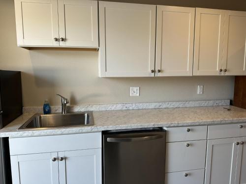 a kitchen with white cabinets and a sink at The GQ Extended Stay in George