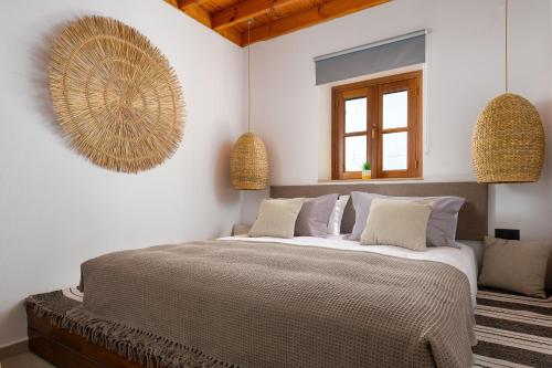 a bedroom with a large bed and two pendant lights at Tapanis luxury house in Líndos