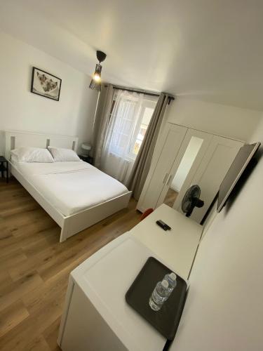 a room with a bed and a desk and a refrigerator at G-Logement-Francilien Aéroport CDG, Parc des expositions Villepinte, Bourget, Astérix. in Goussainville