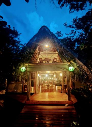 a lit up building with a pyramid roof at night at La Isla Dulce in Lívingston