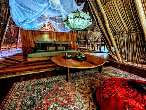 a room with a table and a couch in a yurt at La Isla Dulce in Lívingston