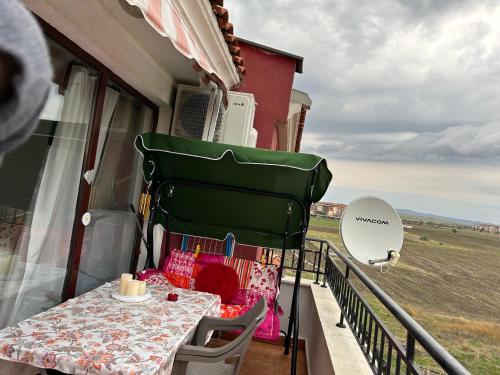 a table on a balcony with a view of a field at Аpartments Comfort -Marina Cape in Aheloy