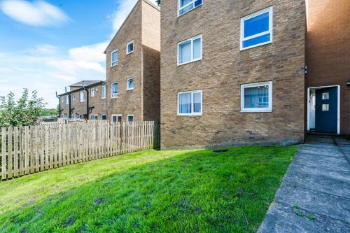 a brick building with a fence in front of it at 2BR Modern Flat With Free Parking - Private Garden in Heeley