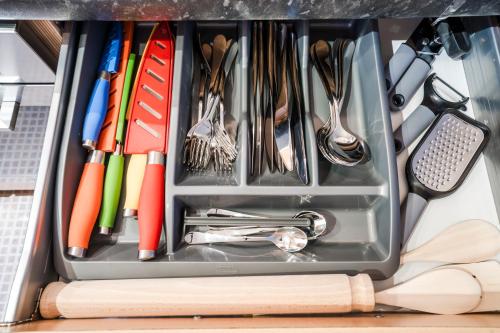 a drawer filled with utensils on a table at 2BR Modern Flat With Free Parking - Private Garden in Heeley