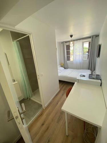 a small room with a bed and a mirror at G-Logement-Francilien Aéroport CDG, Parc des expositions Villepinte, Bourget, Astérix. in Goussainville