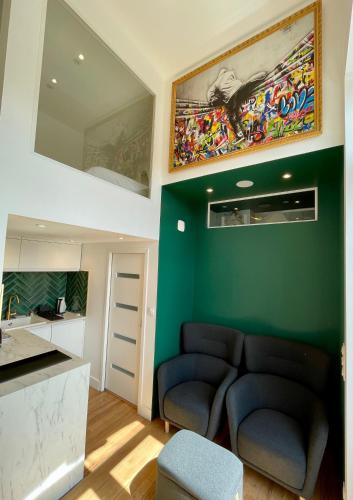 - un salon avec un canapé et un mur vert dans l'établissement Le Five - Villa la Potinière - Front de mer, à Dunkerque