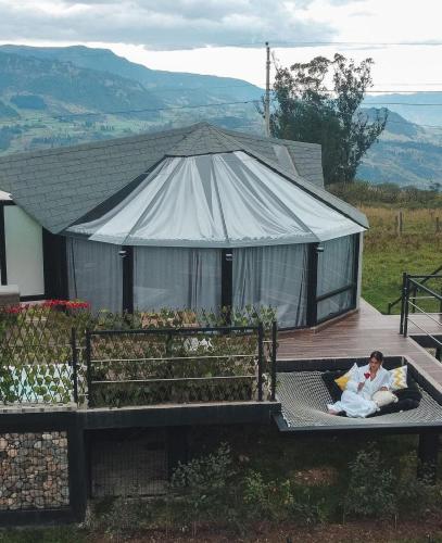 a man laying on a bed in front of a tent at Glamping Al Pie del Cerro in San Fernando