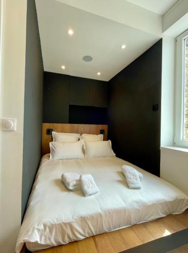 une chambre avec un grand lit blanc avec deux oreillers dans l'établissement Le Eight - Villa la Potinière - Moderne & Intime - Front de mer, à Dunkerque