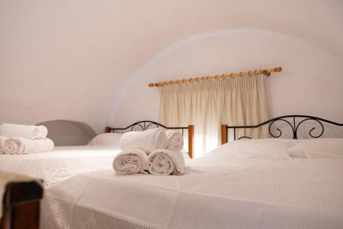 a bedroom with two beds with white sheets and towels at Gabriela's Home in Mestá