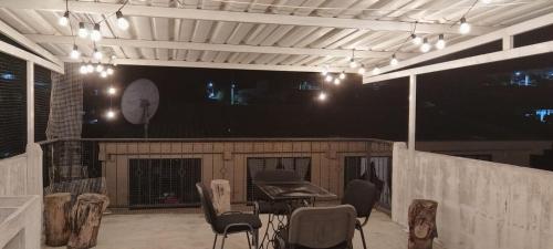 Un patio al aire libre con una mesa y sillas por la noche. en La Posada De Shaz En Norcasia, en Norcasia