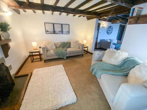 a living room with a couch and a table at Stunning character cottage near Keswick in Threlkeld
