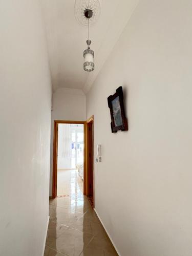 a hallway with a white wall and a ceiling at Blue Pearl Apartments in Chefchaouene