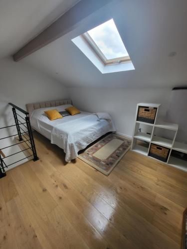 une chambre avec un lit et une lucarne dans l'établissement maison indépendante avec piscine, à Saint-Médard-en-Jalles