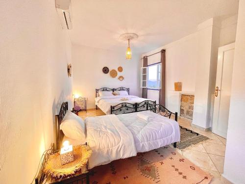 a bedroom with two beds and a window at Dar Bakkali Nadi in Tangier