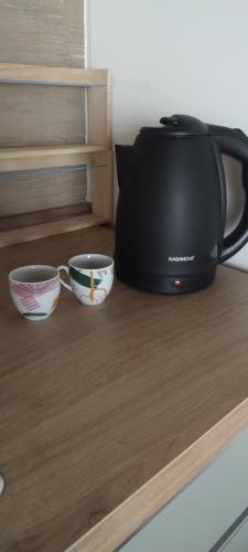a tea kettle and two cups on a counter at La Mansarda in Quarto