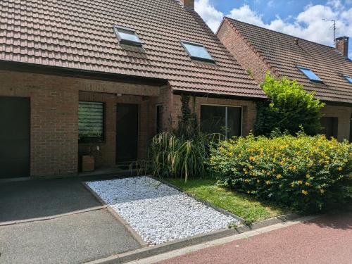 une maison en briques avec un garage et quelques fleurs dans l'établissement La Pléiade, logement chez l'habitant, à Lille