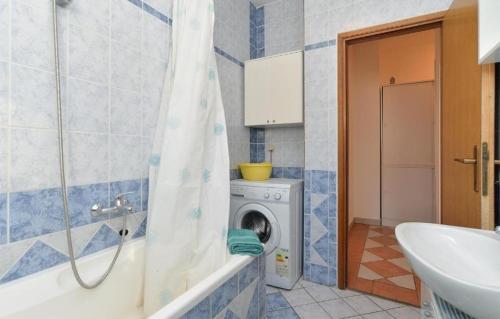 a bathroom with a washing machine and a sink at edwin in Medulin