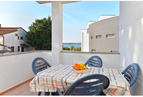 a table with chairs and a bowl of fruit on a balcony at edwin in Medulin