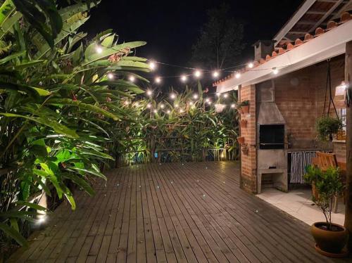 a patio with a bunch of plants and lights at Casa charmosa em Juquehy cercada de verde, 2 quartos com churrasqueira in São Sebastião