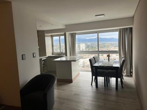 a kitchen and dining room with a table and a large window at Moderno Departamento Piso 16 con pileta in Mendoza