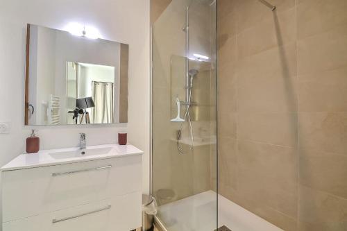 une salle de bain avec une douche, un lavabo et un miroir dans l'établissement Appart de 70m2 en RDC à 6 mn à pied des monuments, à Nîmes