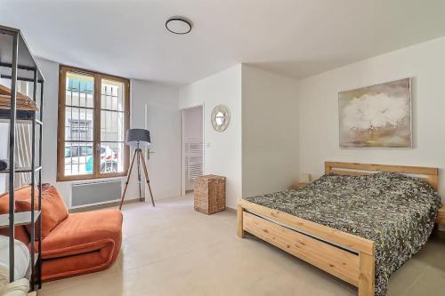 une chambre avec un lit et une chaise dans l'établissement Appart de 70m2 en RDC à 6 mn à pied des monuments, à Nîmes