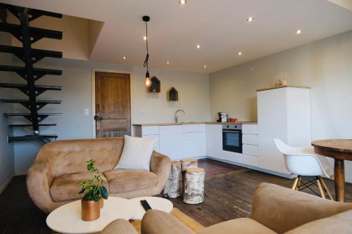 un salon avec des canapés et une table ainsi qu'une cuisine dans l'établissement Nuit en Ville Pompidou Lille La Madeleine, à La Madeleine