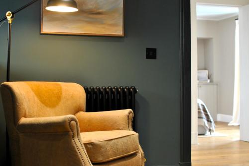 a living room with a chair and a painting on the wall at Kittiwake Cottage- stunning coastal cottage in Anstruther