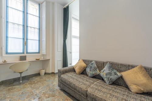 a living room with a couch and two windows at Duomo Smart Suites in Milan