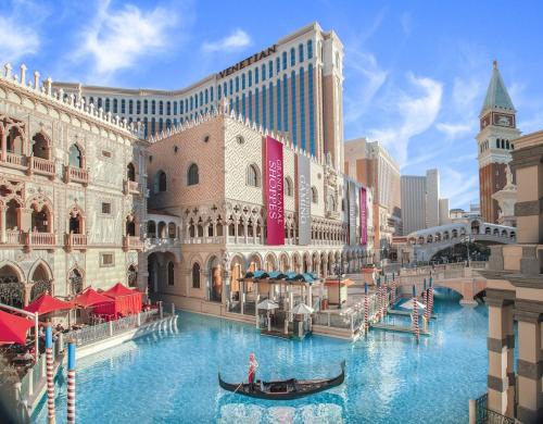 a gondola in front of a building with a casino at The Venetian Resort Las Vegas By Suiteness in Las Vegas