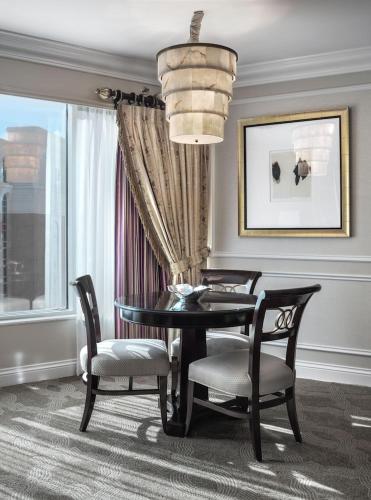 a dining room with a table and chairs and a chandelier at The Venetian Resort Las Vegas By Suiteness in Las Vegas
