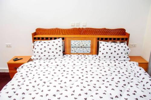 a bed with a black and white comforter and pillows at jodapartment in Gasanze