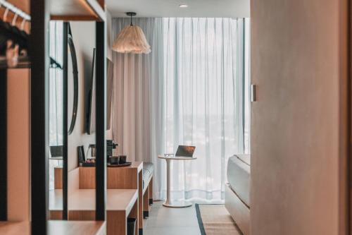 a hotel room with a large window and a desk at Crowne Plaza Merida by IHG in Mérida