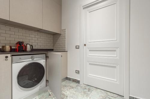 a white door in a kitchen with a washing machine at Duomo Smart Suites in Milan