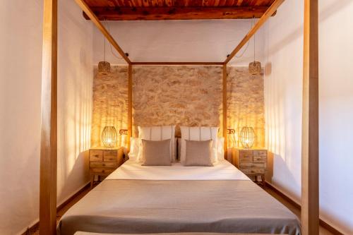 ein Schlafzimmer mit einem Himmelbett mit zwei Nachttischen in der Unterkunft Agroestancia Can Toni Puig in La Mola