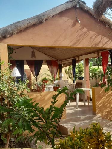 a pavilion with a table and chairs under it at Campement Baobab in Poponguine