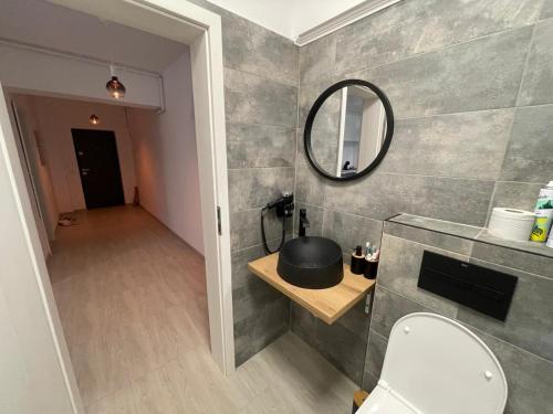 a bathroom with a toilet and a mirror at Apartament Anne Marie - Ibo Residence in Mamaia Nord