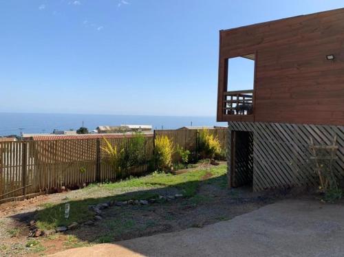 a house with a wooden fence and a gate at Arriendo Diario Casa en la Playa Pelluhue Maule Chile in Pelluhue