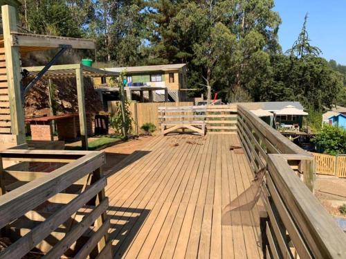 a wooden deck with a fence and a building at Arriendo Diario Casa en la Playa Pelluhue Maule Chile in Pelluhue