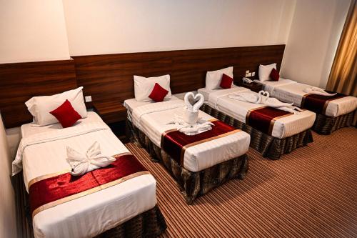 a hotel room with three beds with towels on them at فندق أبراج المسك Abraj Almisk Hotel in Makkah