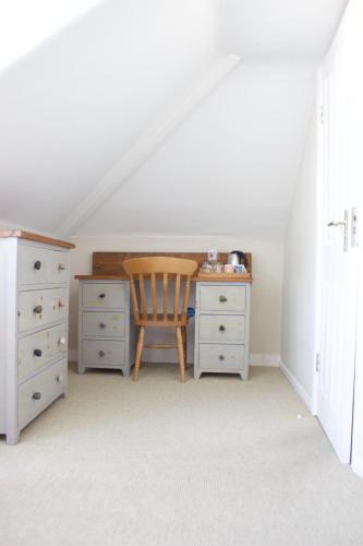 an attic bedroom with a desk and a chair at Durdle Door Hotel in Lulworth Cove