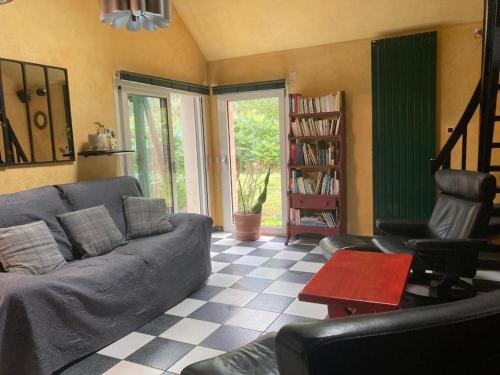 a living room with a couch and a table at La Maison Rose - avec grand jardin clos à 300m de la mer in Hauteville-sur-Mer