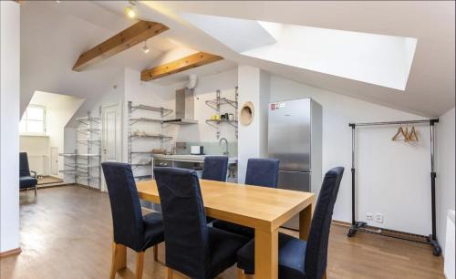 Una cocina y un comedor con mesa y sillas de madera. en Old Town Studio Self Check-in, en Tallin
