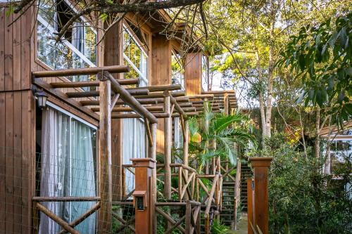 a wooden house with a wooden fence around it at Moradas do Vale Praia do Rosa in Praia do Rosa