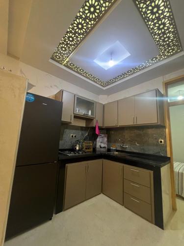a kitchen with a black refrigerator and a ceiling at lala aicha house in Tamri