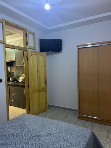 a room with a bed and a door and a kitchen at lala aicha house in Tamri