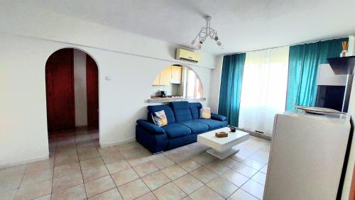 a living room with a blue couch and a table at Arad central apartment in Arad