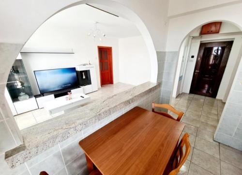 a dining room with a table and a tv on a wall at Arad central apartment in Arad