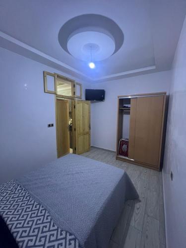 a bedroom with a bed and a television in it at lala aicha house in Tamri