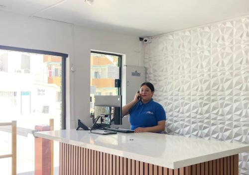 a woman sitting at a desk talking on a cell phone at Hotel Guillen in Tijuana